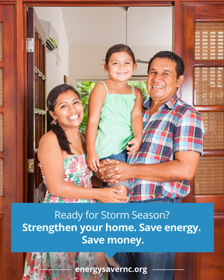 A smiling family of three stands in the doorway of their home. Text below promotes strengthening your home to save energy and money.